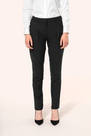 Jeune femme portant un pantalon City noir élégant, confectionné dans une matière de qualité offrant confort et tenue impeccable. Elle l’associe à une chemise blanche et à des escarpins noirs pour une silhouette raffinée et intemporelle.