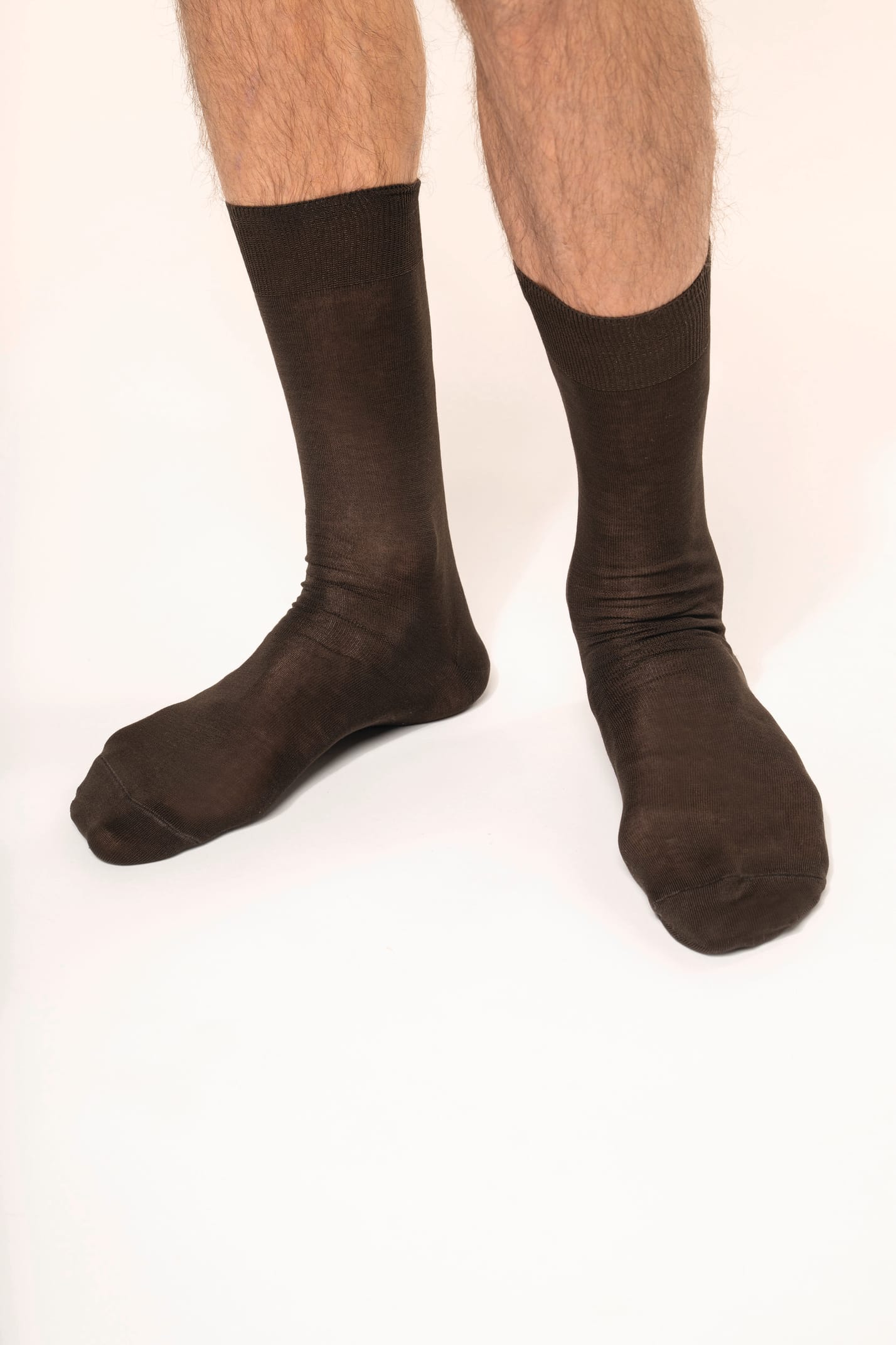 Homme qui porte une paire de chaussettes jersey coton fil d'Écosse coloris chocolat.