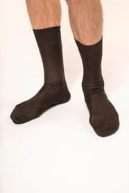 Homme qui porte une paire de chaussettes jersey coton fil d'Écosse coloris chocolat.