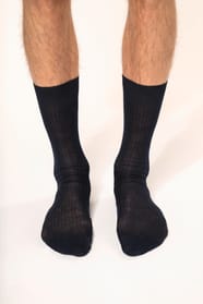 Homme qui porte une paire de chaussettes coton rib 4x2 fil d'Écosse coloris bleu marine.