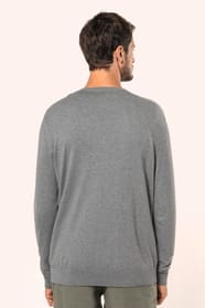Jeune homme portant un pull gris clair chiné en coton Supima® col rond. Confectionné en fibres extra-longues, ce coton d’exception offre souplesse, douceur et durabilité. Sa maille révèle des points fantaisie obtenus par une technique de tricotage spécifi