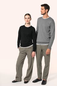 Jeune homme aux cheveux châtains courts et jeune femme aux cheveux châtains longs attachés en queue de cheval portent chacun un pull en coton Supima® col rond, reconnu pour la souplesse, la douceur et la durabilité de ses fibres extra-longues. Lui opte po