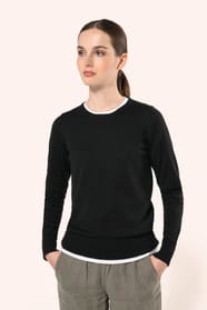 Jeune femme aux cheveux châtains longs attachés en queue de cheval portant un pull noir en coton Supima® col rond. Confectionné en fibres extra-longues, ce coton d’exception offre souplesse, douceur et durabilité. Sa maille révèle des points fantaisie obt