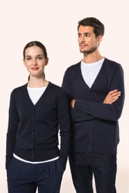 Jeune homme aux cheveux châtains courts et à la barbe naissante et jeune femme aux cheveux châtains longs attachés portent chacun un cardigan bleu profond en coton Supima®. Les fibres extra-longues de ce coton d’exception offrent souplesse, douceur et dur