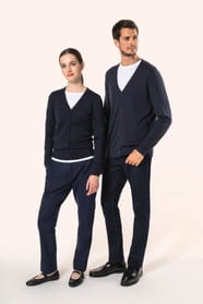 Jeune homme aux cheveux châtains courts et à la barbe naissante et jeune femme aux cheveux châtains longs attachés portent chacun un cardigan bleu profond en coton Supima®. Les fibres extra-longues de ce coton d’exception offrent souplesse, douceur et dur