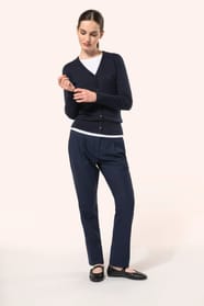 Jeune femme aux cheveux châtains longs attachés portant un cardigan bleu profond en coton Supima®. Ses fibres extra-longues apportent souplesse, douceur et durabilité à une maille de qualité supérieure. Confectionné en jauge 12 selon la technique fully-fa