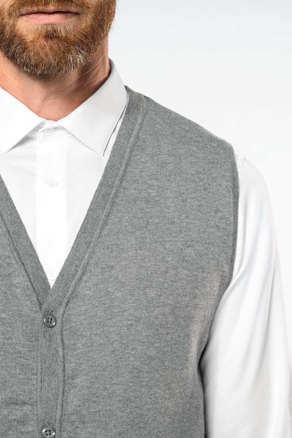 Homme châtain doré portant un gilet élégant en coton Supima® gris clair.