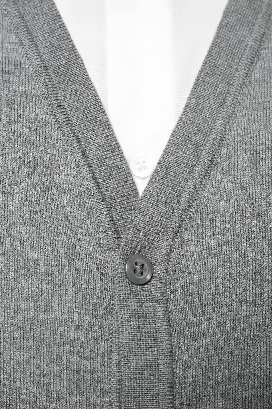 Homme châtain doré portant un gilet élégant en coton Supima® gris clair.