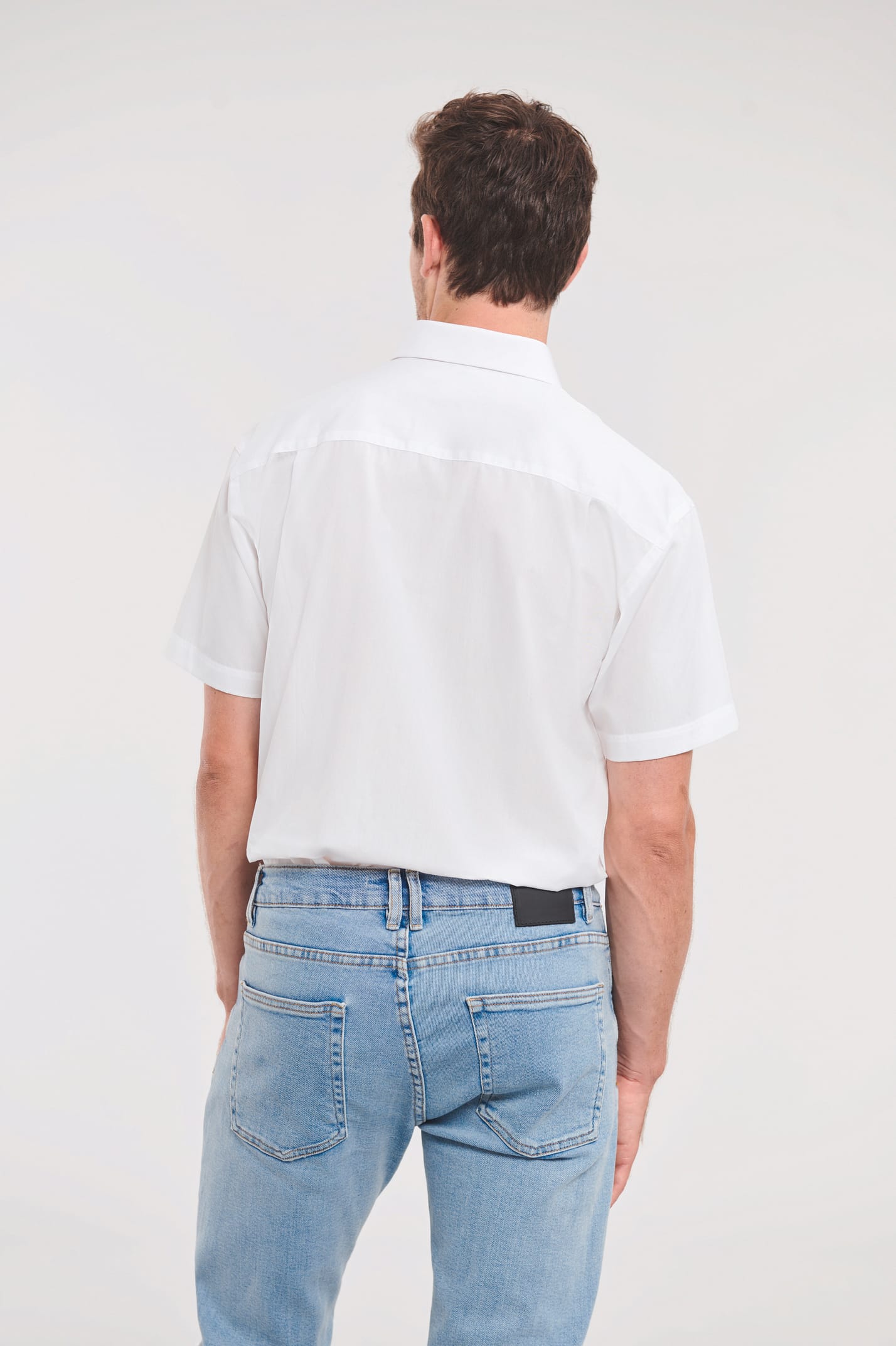 chemise blanche manches courtes portée rentrée dans un jean par un homme