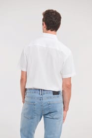 chemise blanche manches courtes portée rentrée dans un jean par un homme
