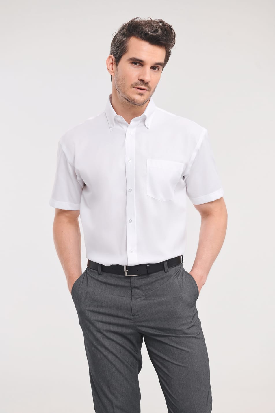 chemise blanche manches courtes col italien et poche poitrine côté gauche portée rentrée dans le pantalon par un homme