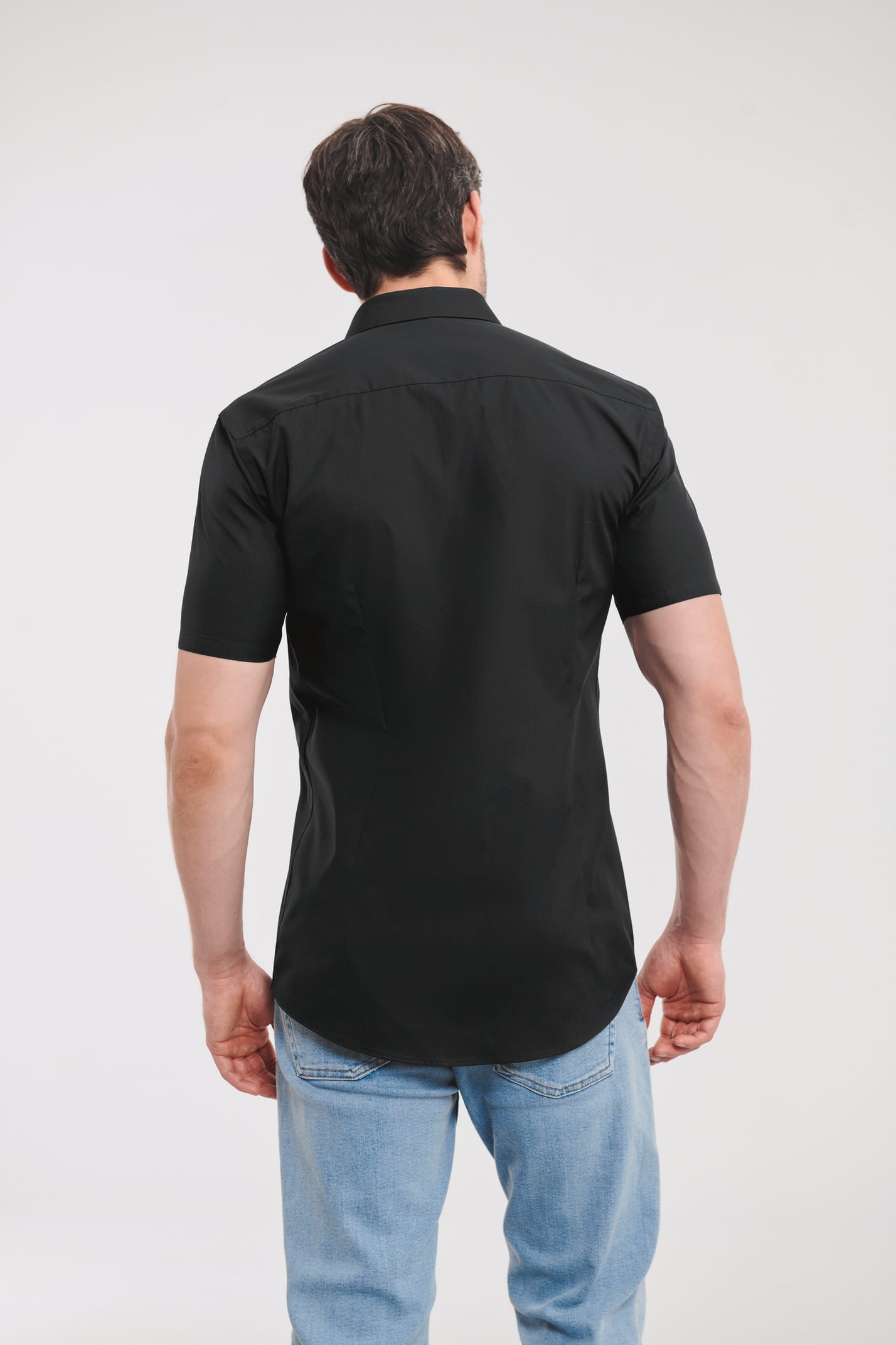 chemise noire manches courtes coupe ajustée portée par un homme vu de dos