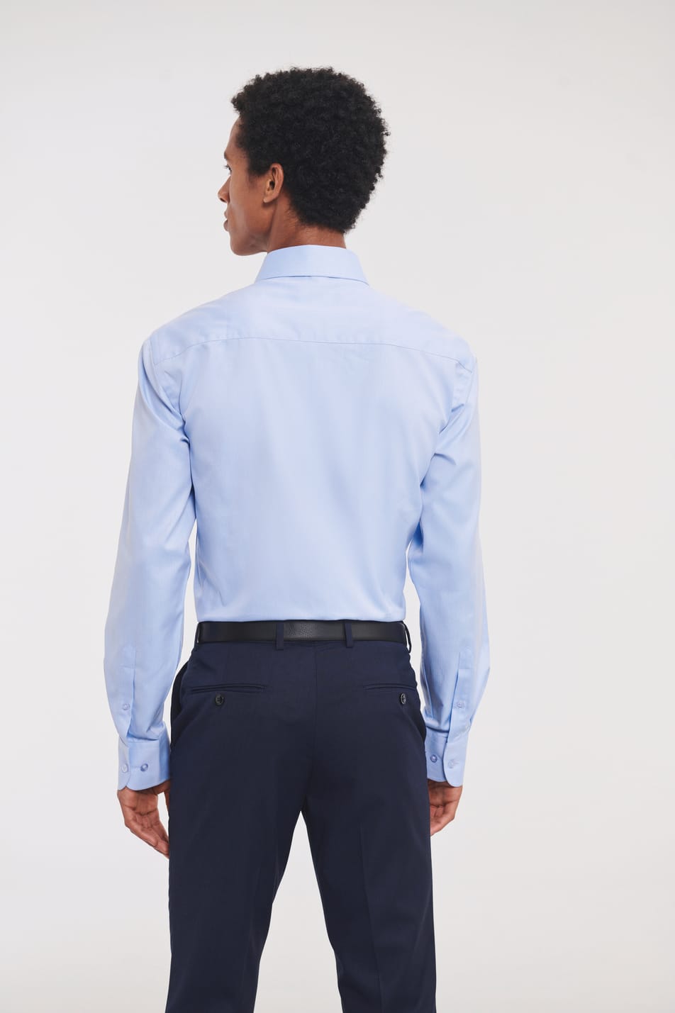 chemise bleu clair manches longues coupe ajustée portée rentrée dans le pantalon par un homme vu de dos