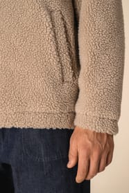 Manche de sweat 1/4 zip en sherpa beige portée par un homme 