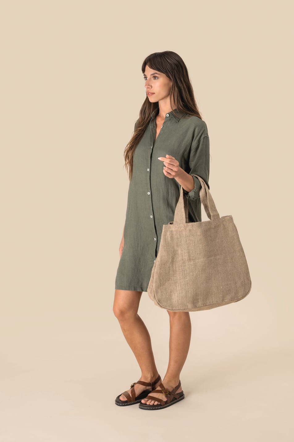 Robe chemise en lin kaki et sac en jute portés par une femme 