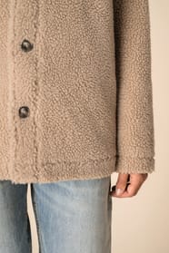 Détail de la manche d'une surchemise en sherpa beige portée par une femme