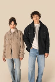 Surchemises en sherpa beige et noire portées par un homme et une femme