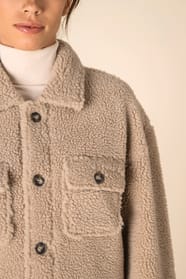Col d'une surchemise en sherpa beige portée par une femme