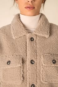 Col d'une surchemise en sherpa beige portée par une femme