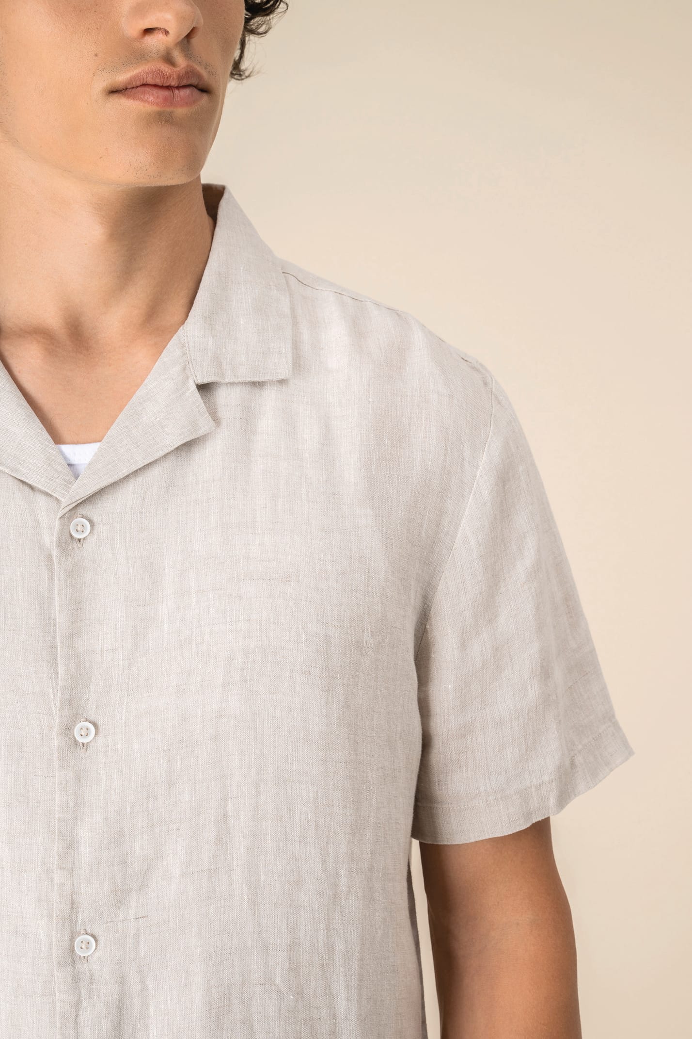 Détail épaule chemise à manches courtes en lin beige portée par un homme