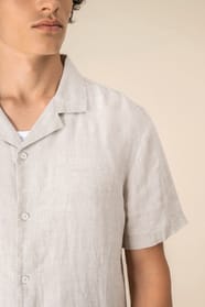 Détail épaule chemise à manches courtes en lin beige portée par un homme