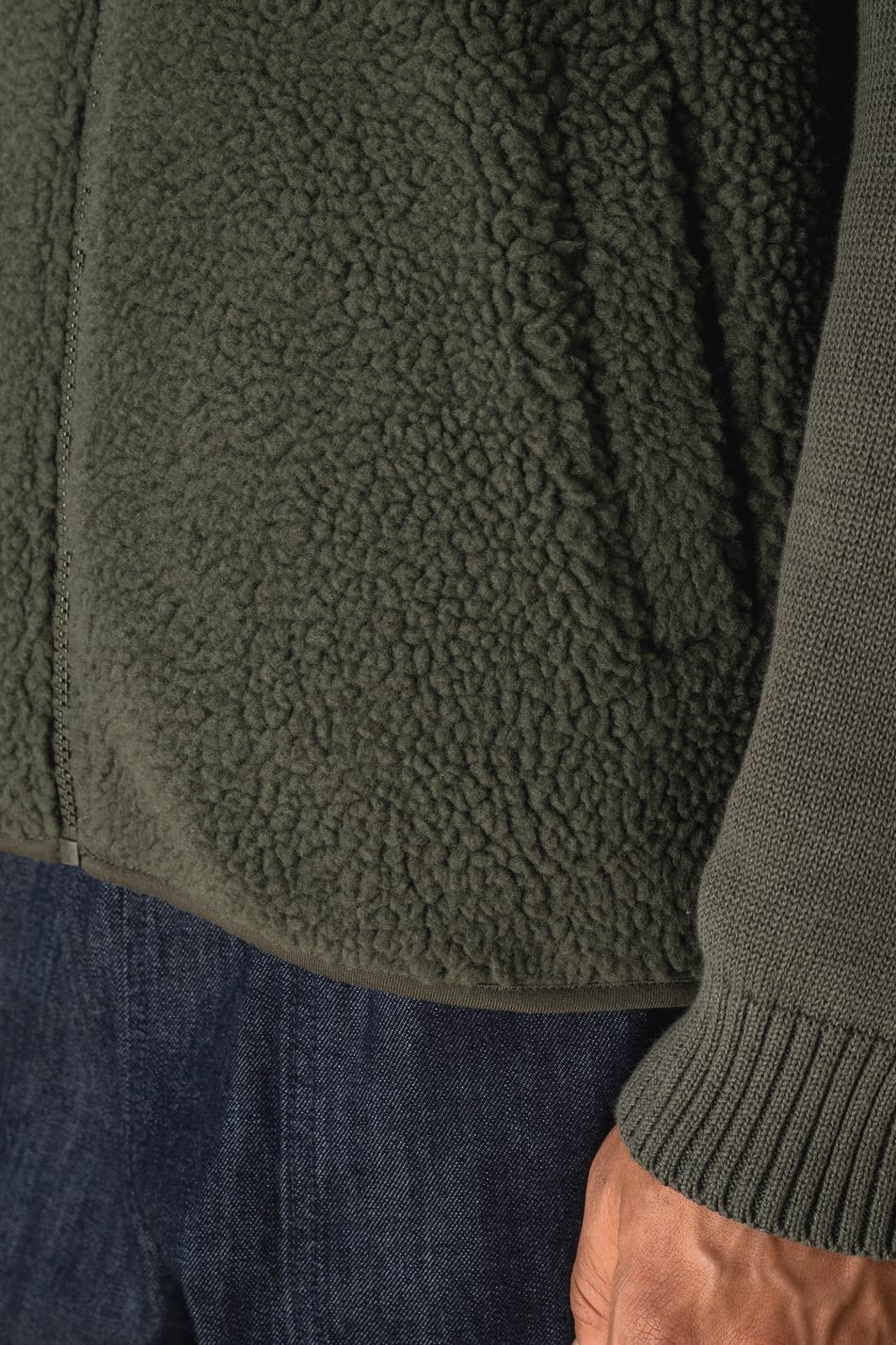 Détail de la poche d'une veste sans manches en sherpa kaki portée par un homme