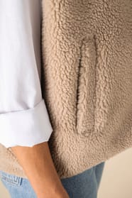 Détail d'une poche d'un veste sans manches en sherpa beige portée par une femme