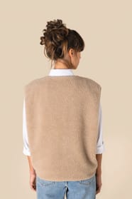 Veste sans manches en sherpa beige portée par une femme de dos