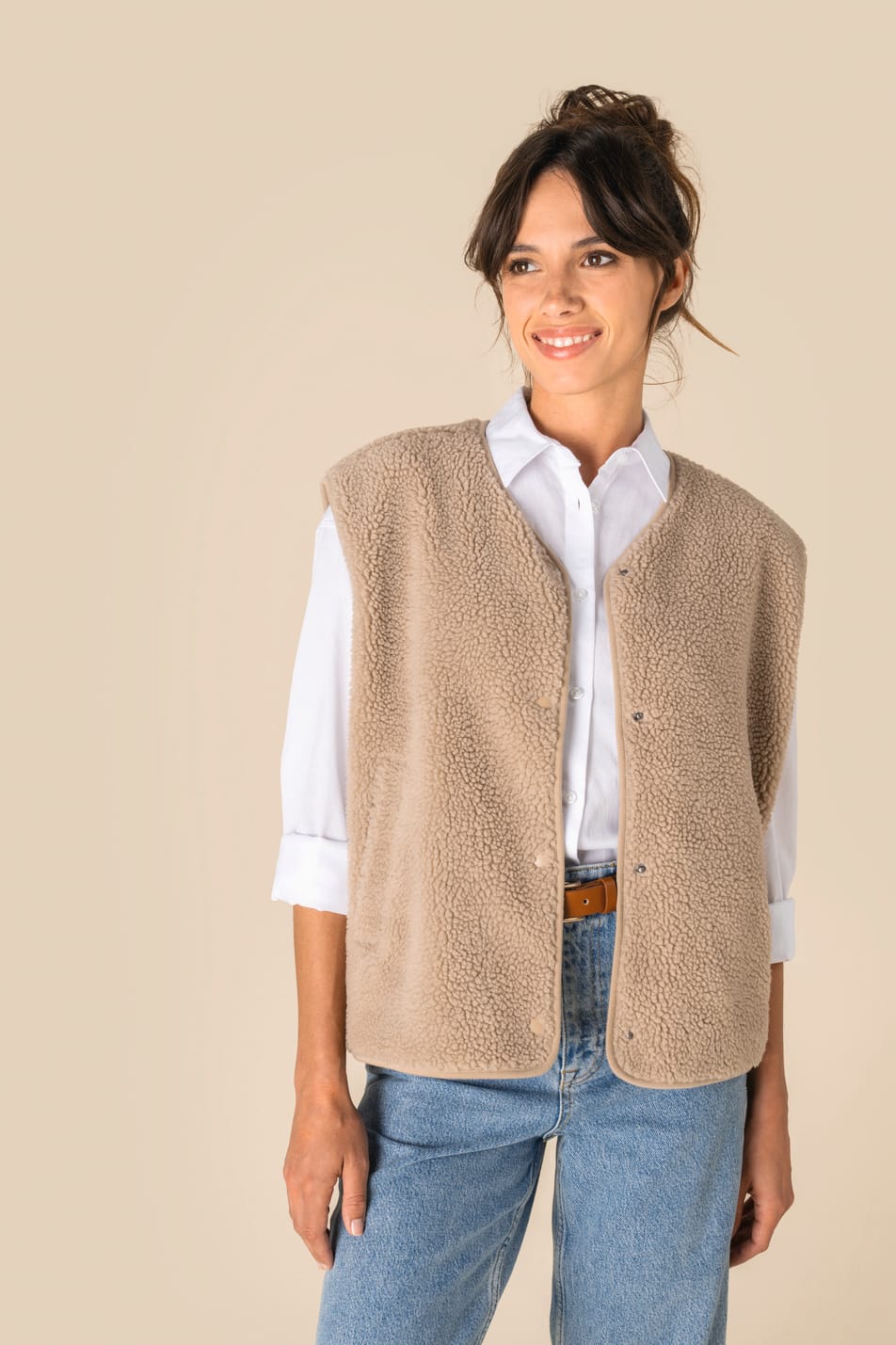 Veste sans manches en sherpa beige portée par une femme