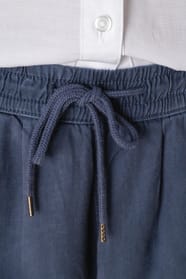 Détail des cordons d'un pantalon délavé en lyocell bleu portée par une femme