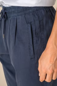 Détail des poches d'un pantalon délavé en lyocell bleu portée par une femme