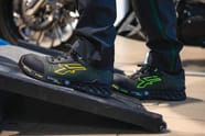 chaussure de sécurité basse vert et noir à lacets avec semelle multi-résistante portée dans un atelier