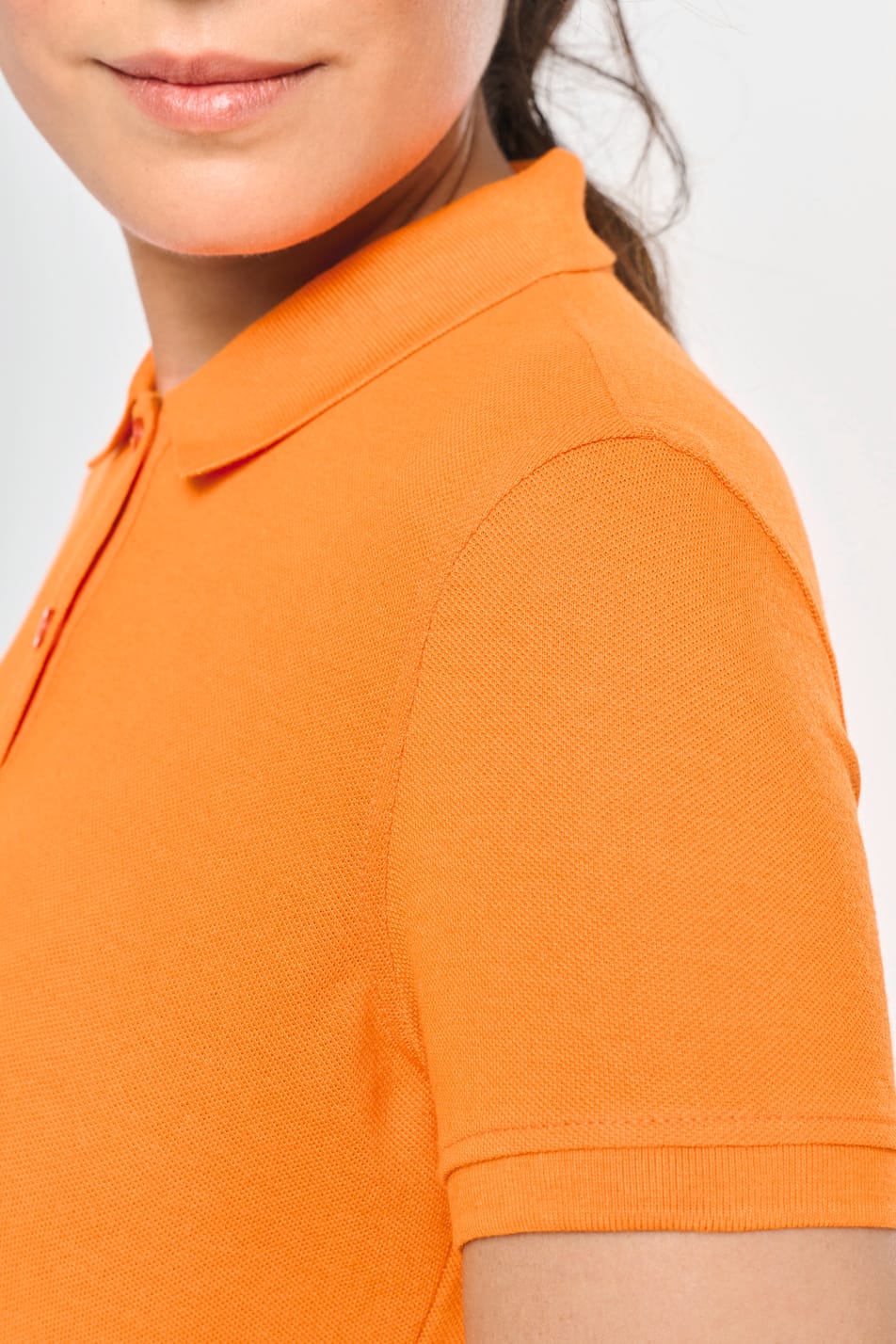 Elle porte un polo manches courtes