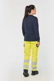 Pantalon de travail haute visibilité jaune fluo porté par une femme
