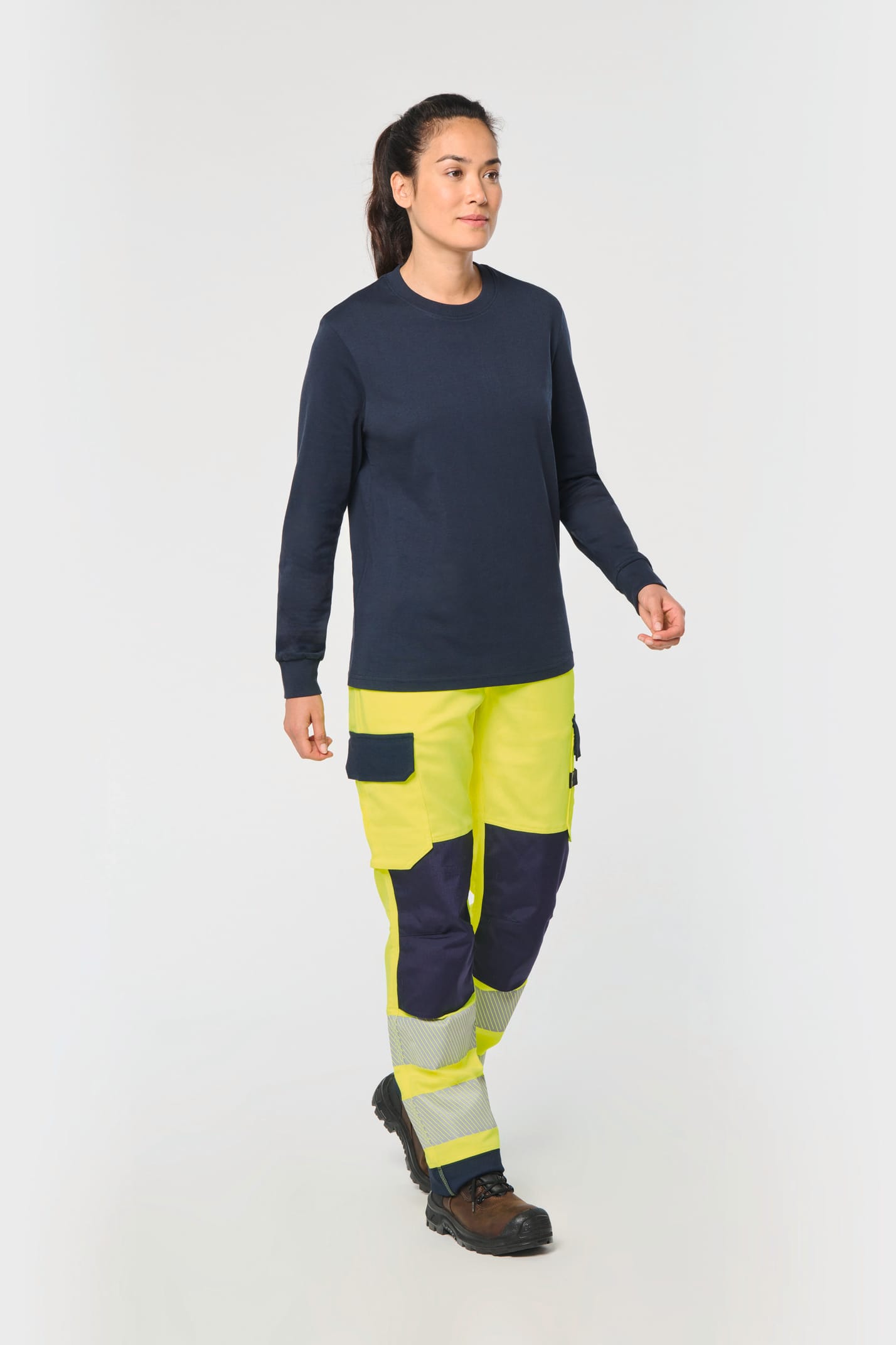 Pantalon de travail haute visibilité jaune fluo porté par une femme