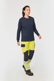 Pantalon de travail haute visibilité jaune fluo porté par une femme