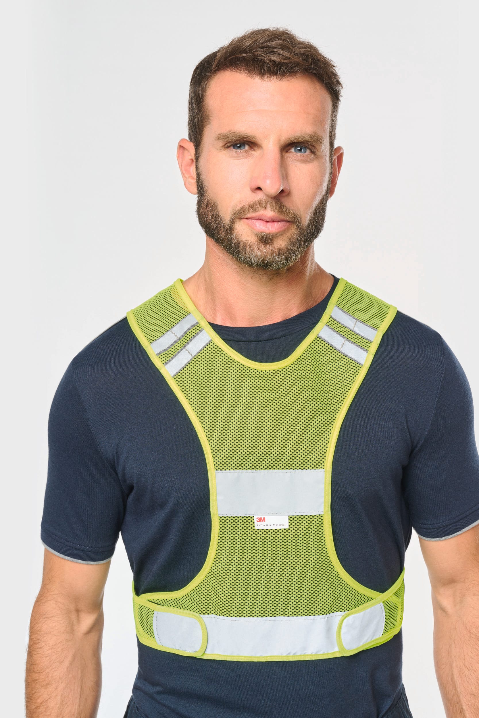 Il porte un gilet en filet fluorescent