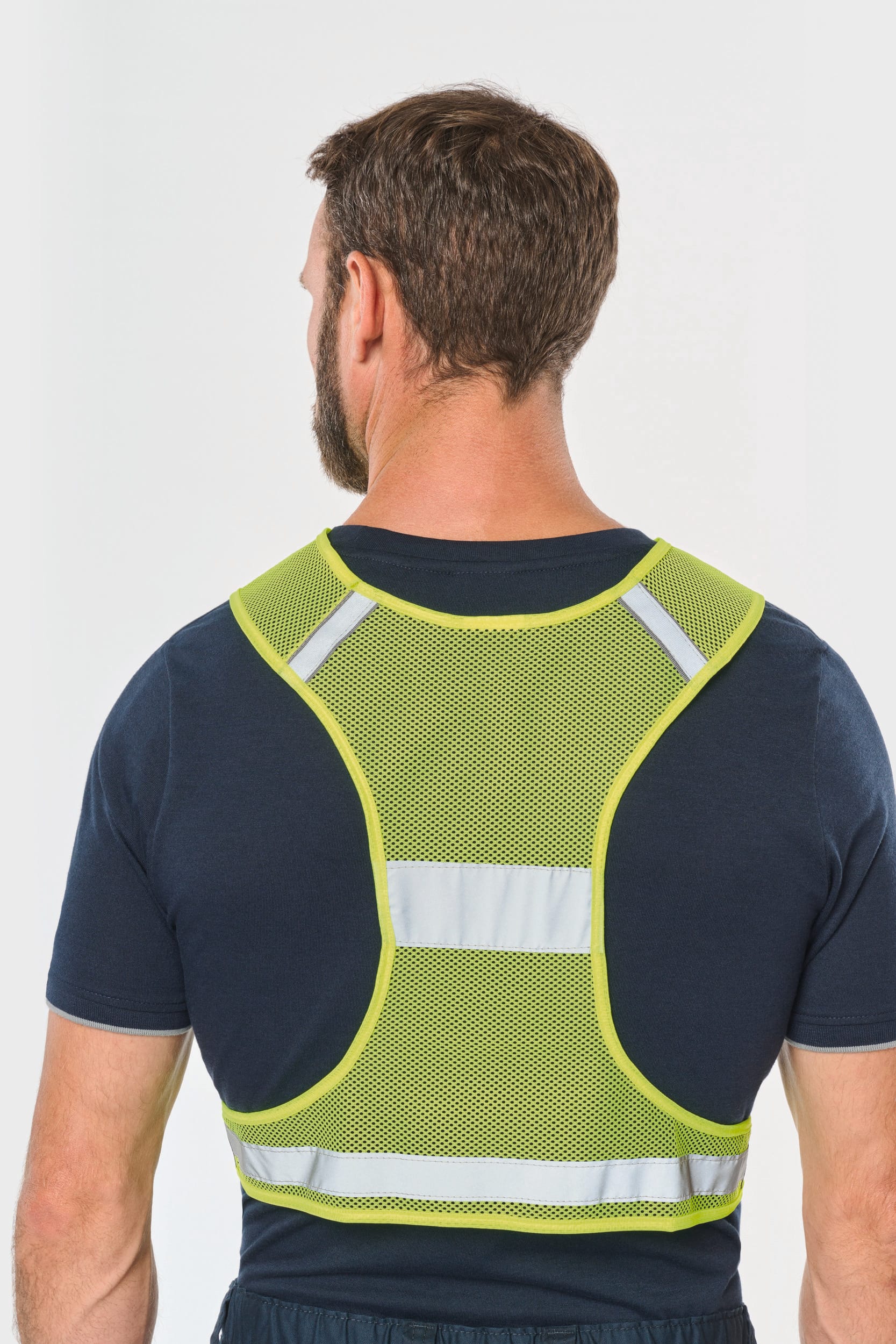 Il porte un gilet en filet fluorescent