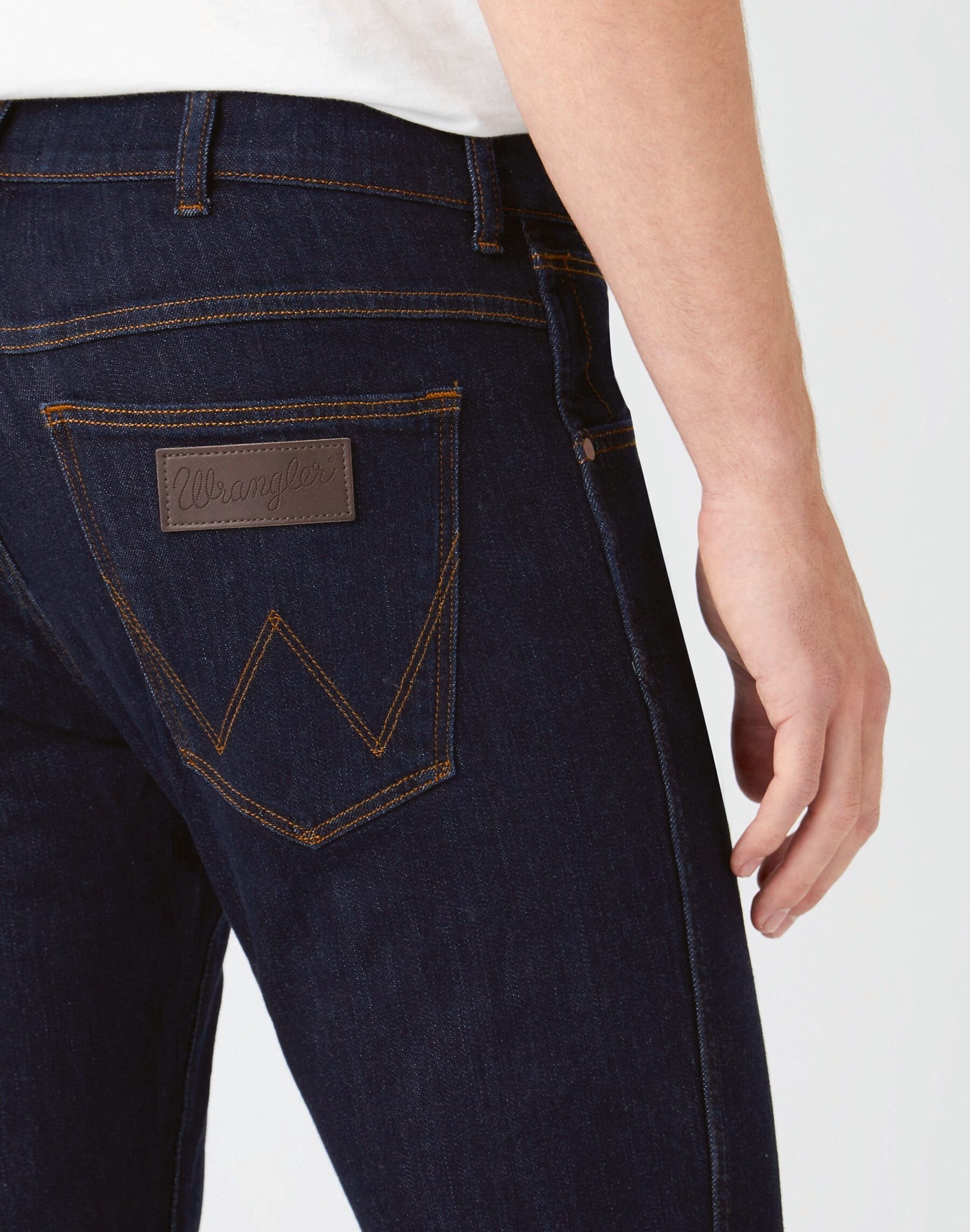détail poche arrière sur jean slim noir porté par un homme