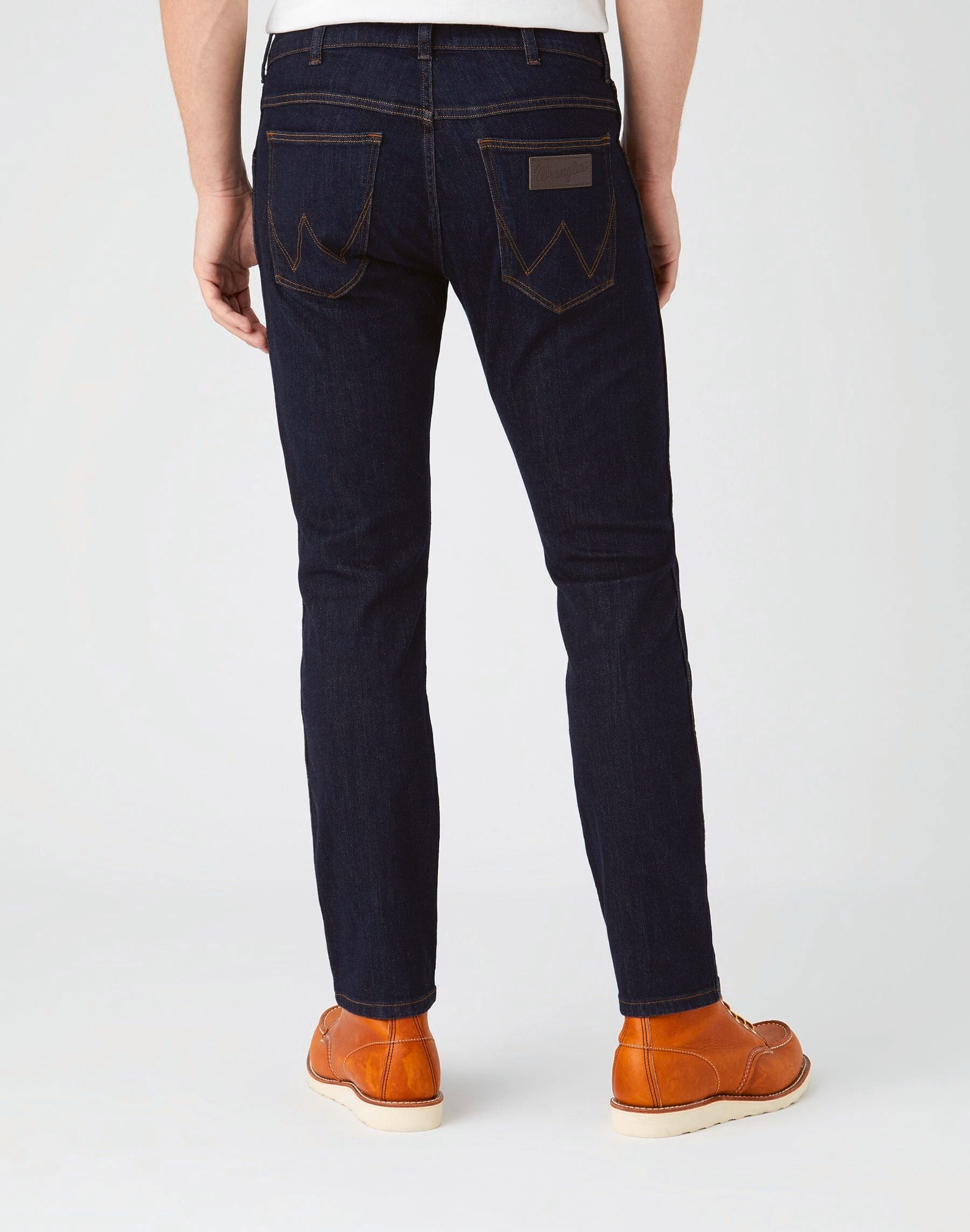 jean noir coupe slim porté par un homme vu de dos