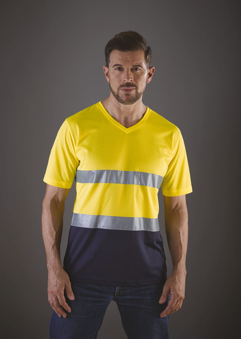 t-shirt bicolore jaune fluo et bleu foncé haute visibilité avec bandes réfléchissantes manches courtes porté par un homme debout