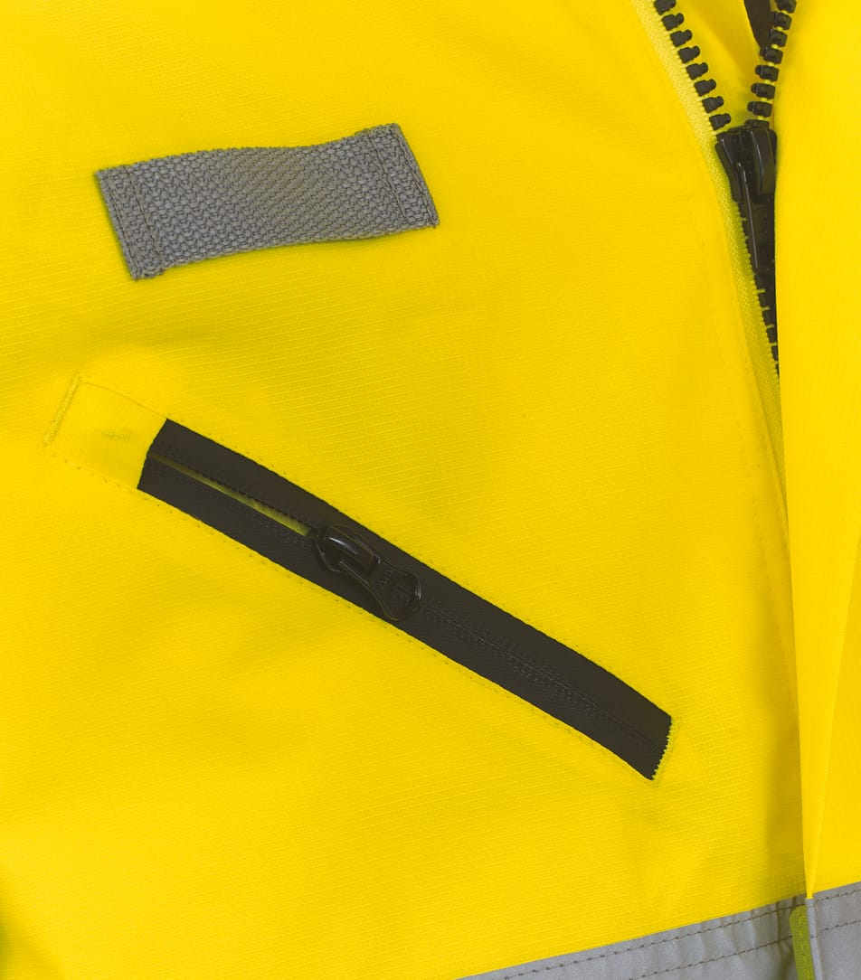 détail poche zippée sur veste jaune fluo haute visibilité avec bandes réfléchissantes