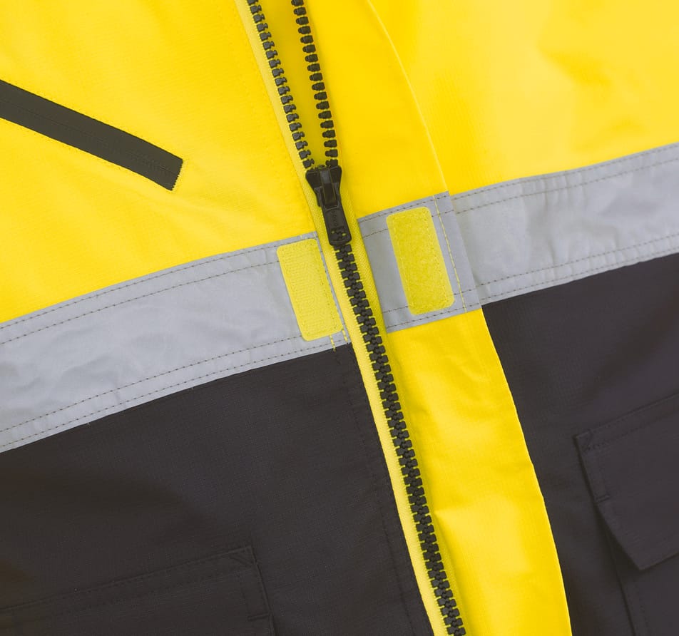 détail zip sur veste bicolore jaune fluo et bleu foncé avec bandes réfléchissantes