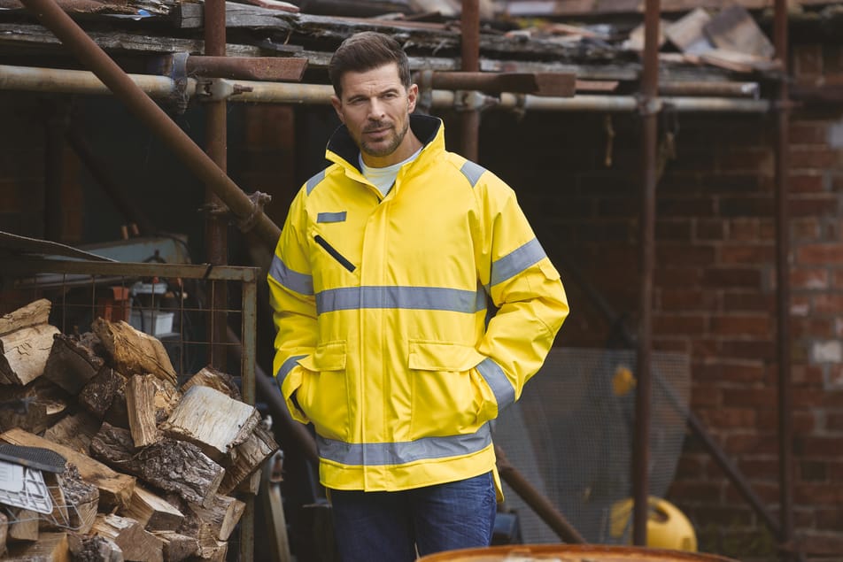 veste jaune fluo haute visibilité avec bandes réfléchissantes fullzip multipoches col montant avec les mains dans les poches