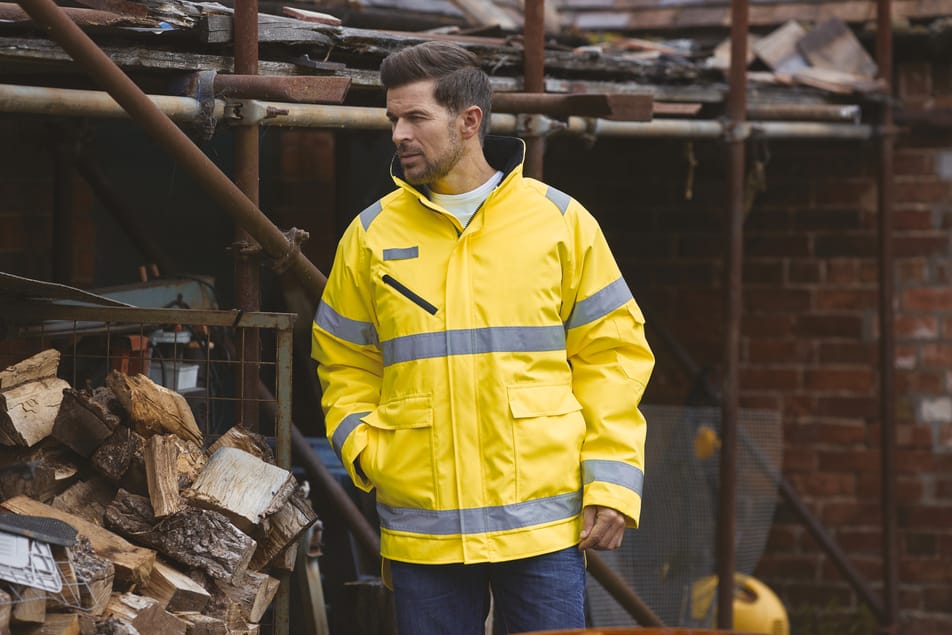 veste jaune fluo haute visibilité avec bandes réfléchissantes fullzip multipoches col montant portée par un homme debout