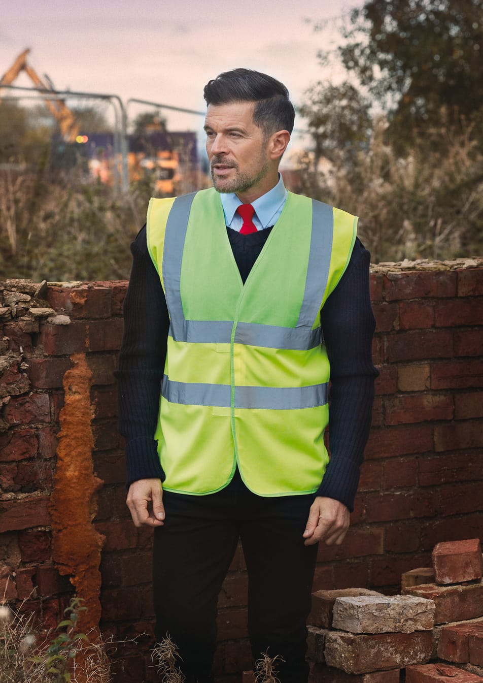 veste jaune fluo et bandes réfléchissantes sans manches portée par un homme 