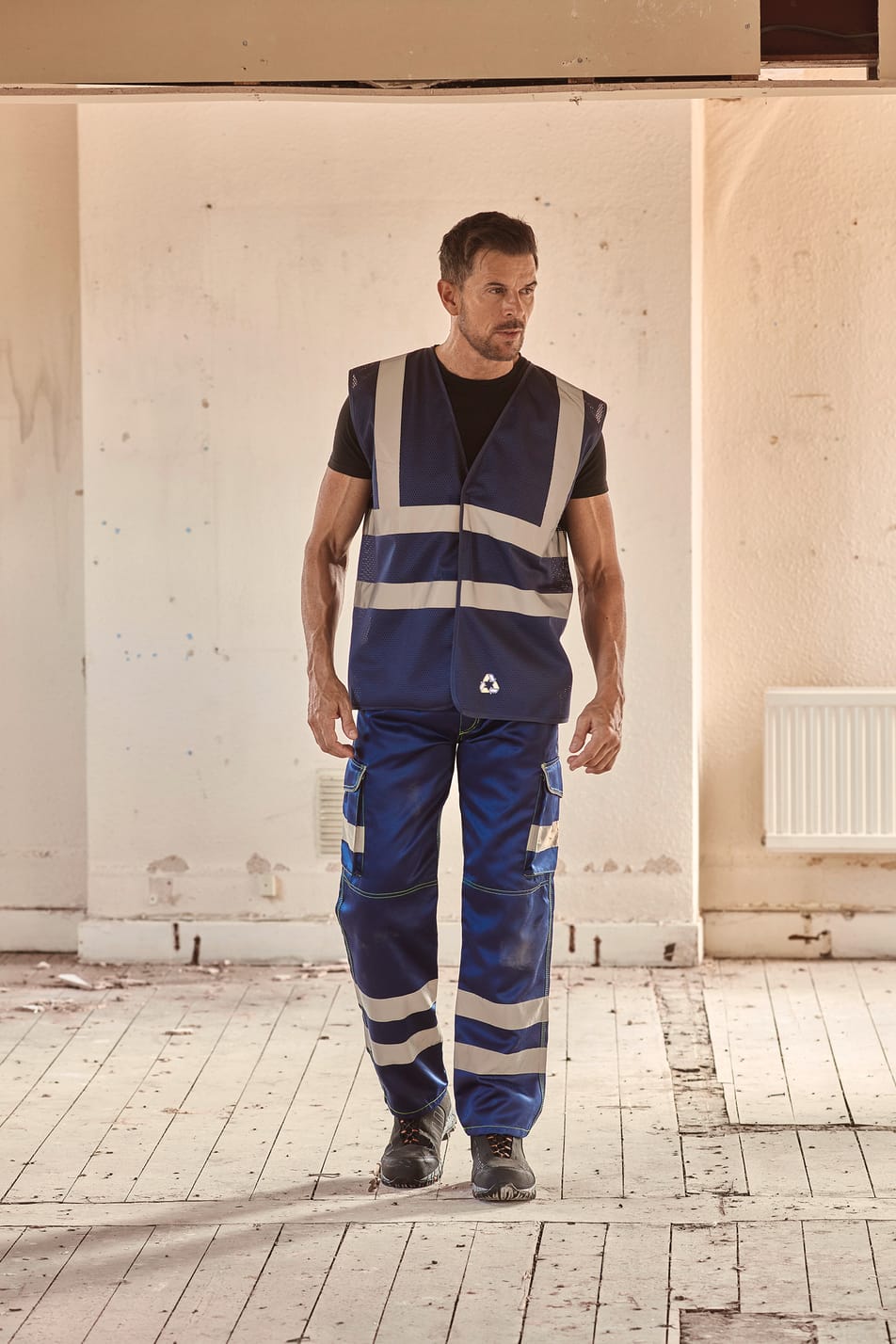 gilet sans manches bleu foncé avec bandes réfléchissantes haute visibilité porté par un homme avec un pantalon bleu
