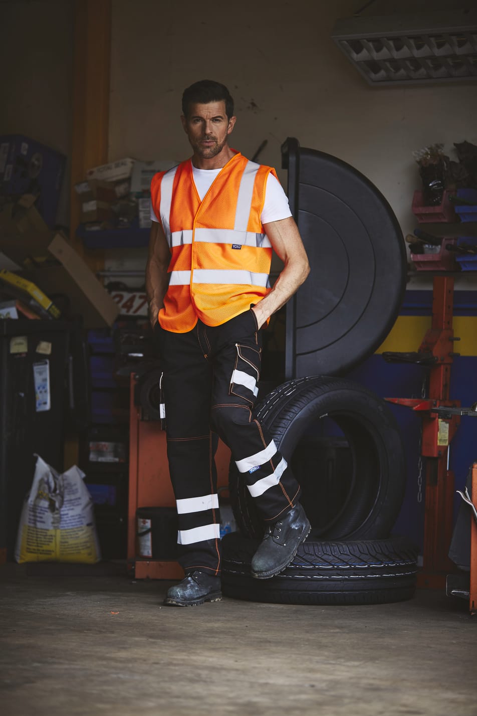 gilet orange fluo haute visibilité avec bandes réfléchissantes sans manches fermeture velcro porté par un homme